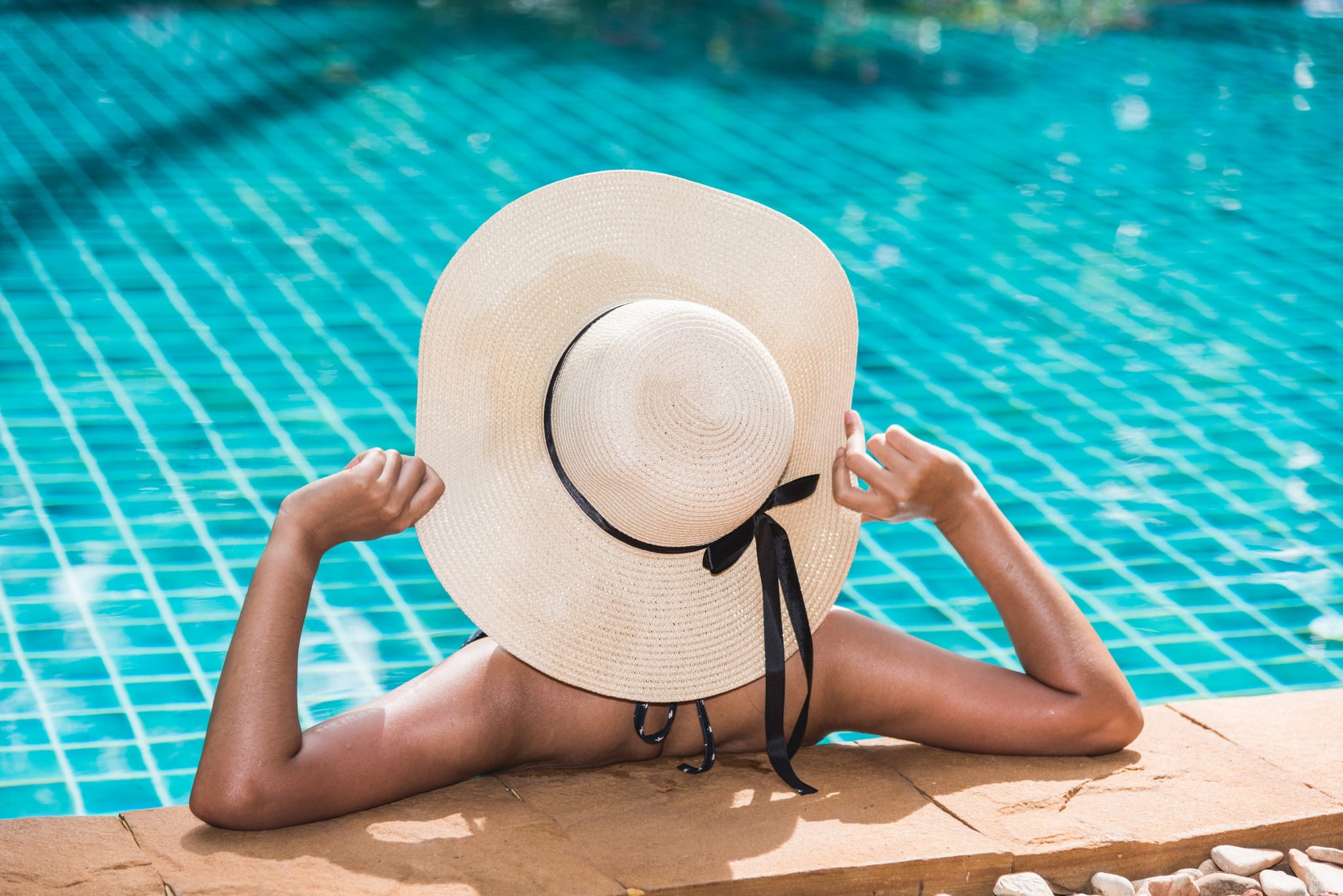 Personne avec chapeau au bord de la piscine, Hôtel près de Sarlat avec Piscine, Maison Borrèze.
